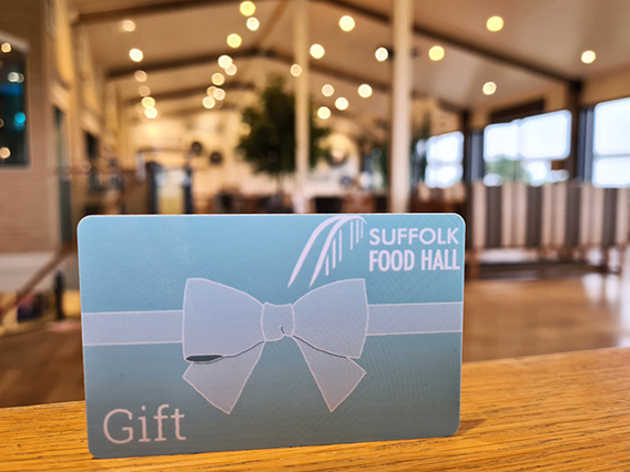 A Gift Card makes the perfect present, displayed on a wooden table in a bright dining area.