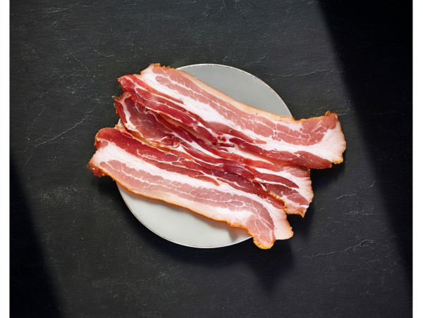 Three Smoked Streaky Bacon rashers on a small grey plate, set against a dark, textured background.